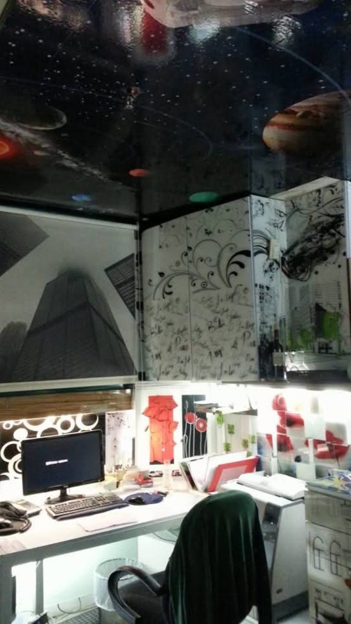 Decorative wall panels and materials beneath the dark, illustrated workshop ceiling.
